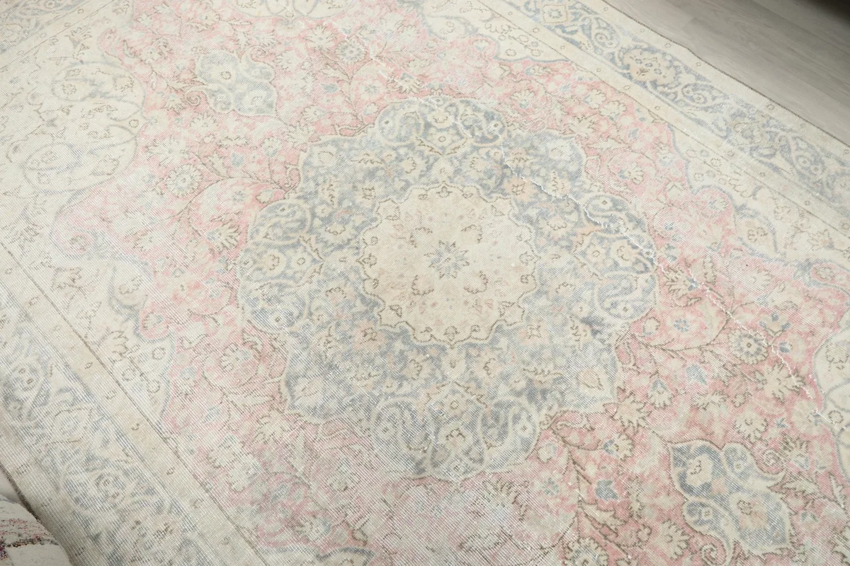 Close-up view of the central medallion with blue and rose tones and subtle wear
