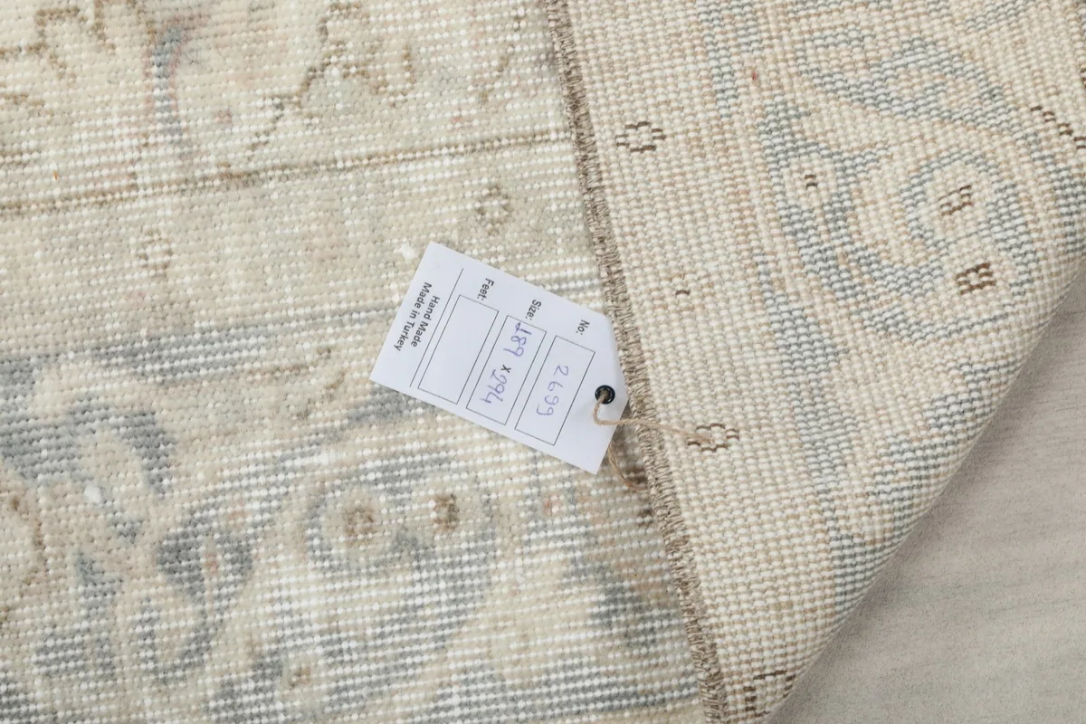 Close-up of the rug's back with a tag, showing the reverse of the hand-knotted construction