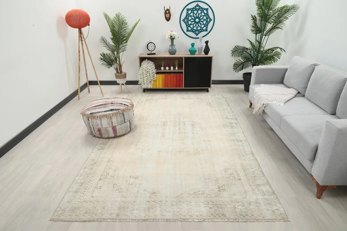 Ivory and green vintage rug in a modern living room setting with a gray sofa