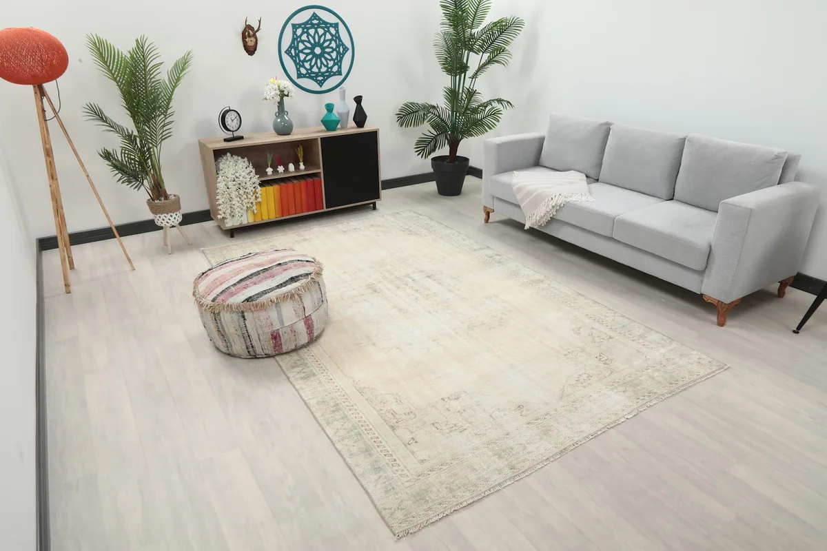 Angle view of the ivory and green rug in a living room, showing its placement