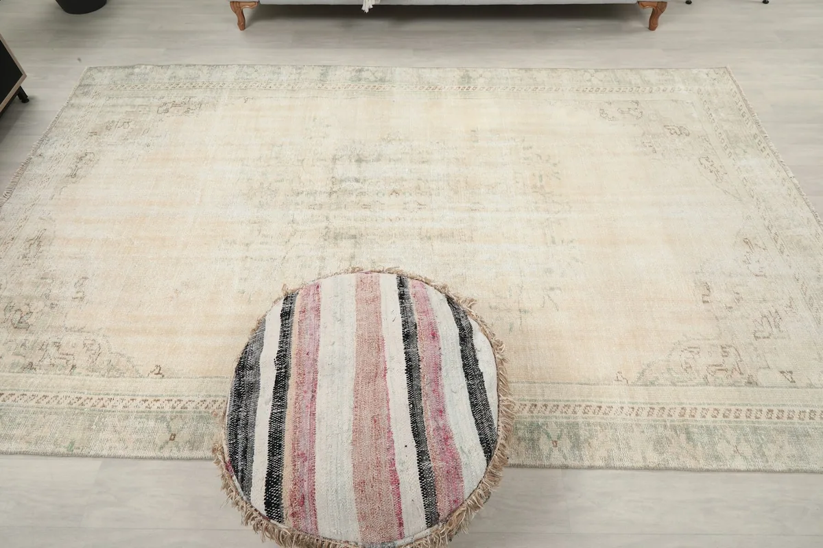 Overhead view showcasing the full spread of the ivory and green rug on the floor