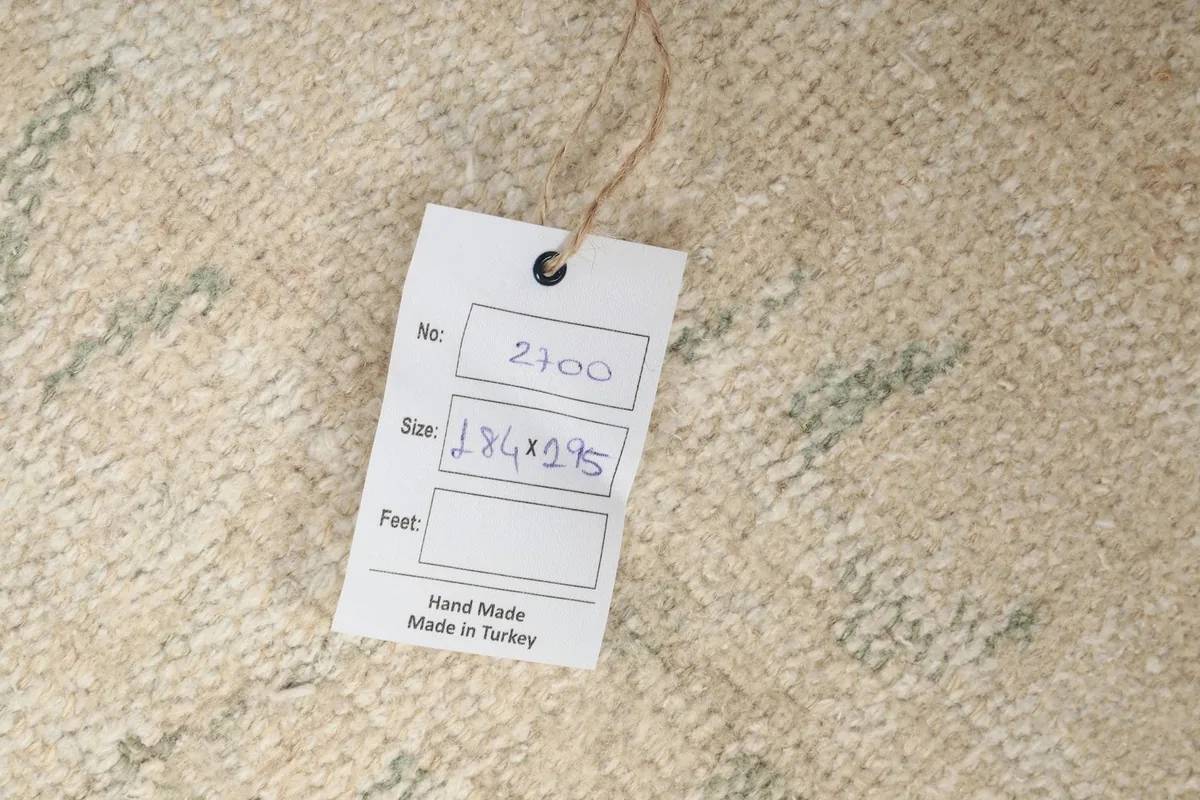 Tag displaying the rug's dimensions in centimeters, confirming its origin and craftsmanship