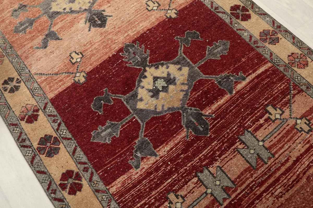Overhead detail of a central geometric motif on the red field of the runner