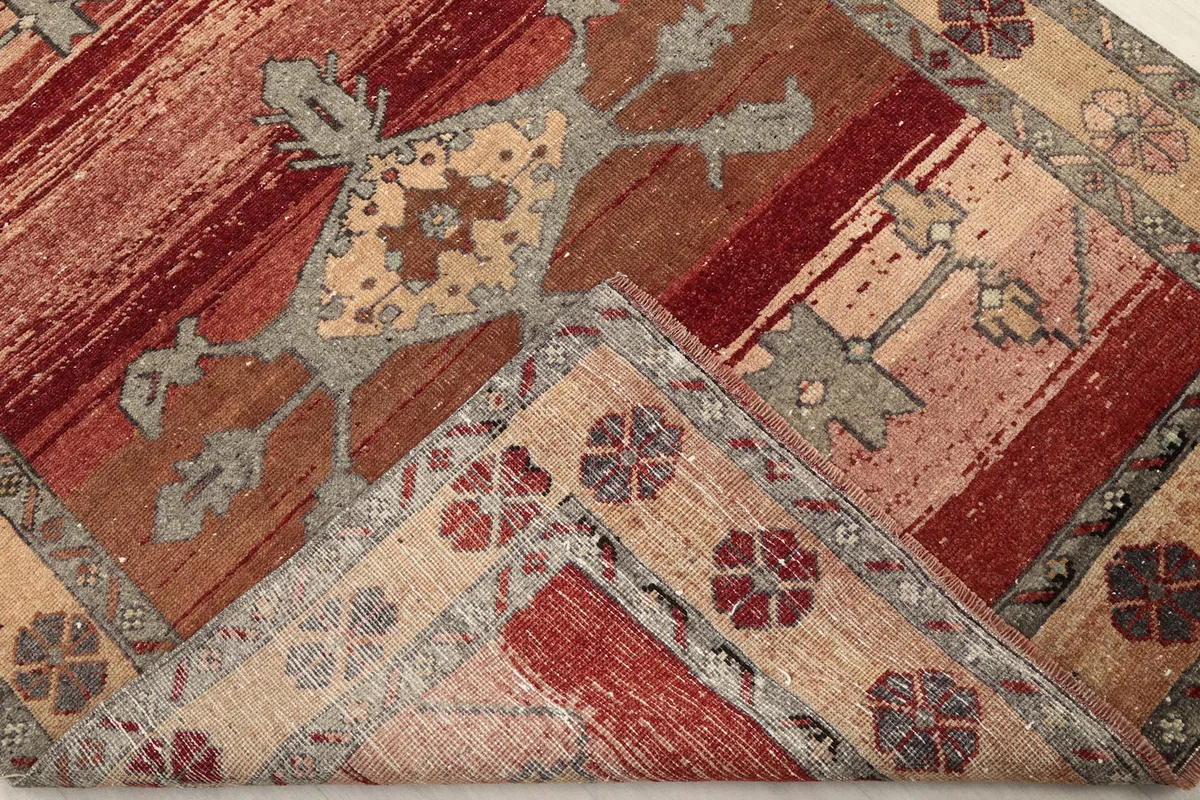 Folded corner of the rug, revealing the hand-knotted wool pile and cotton foundation