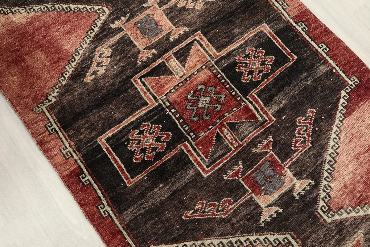 Mid-section close-up of the runner, highlighting the intricate tribal motifs in charcoal and rust.