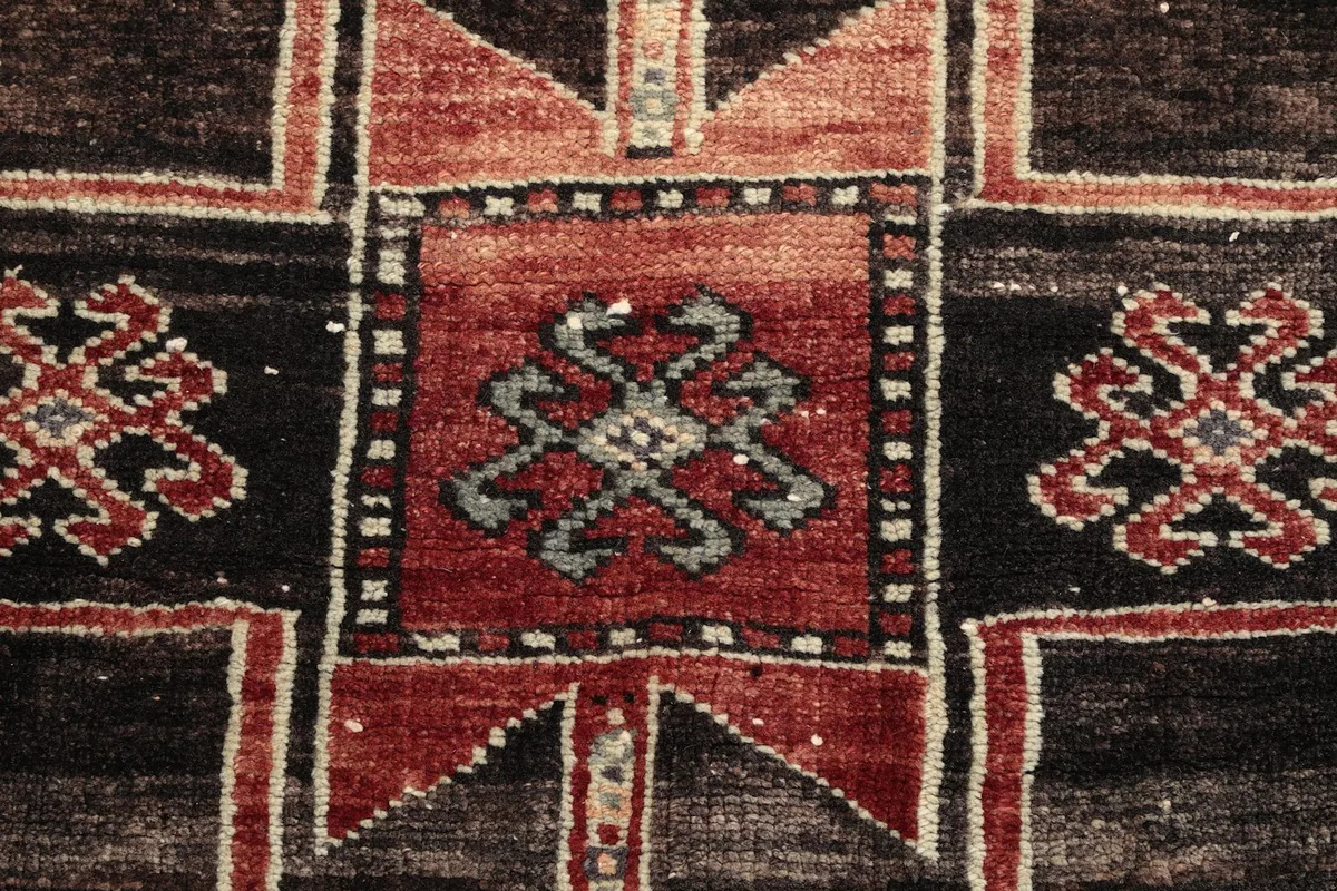 Extreme close-up of a central motif, revealing knotting and subtle color variations.
