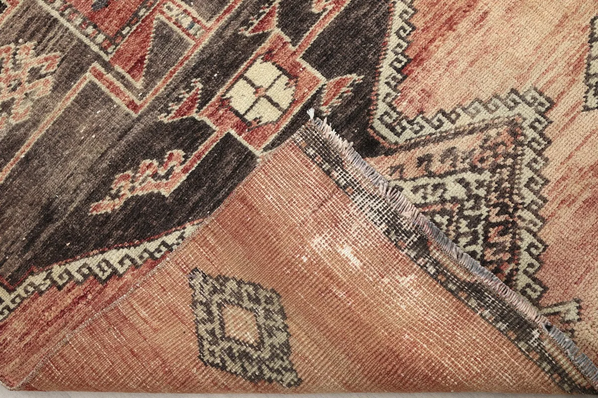 View of the back of the rug, folded to show the cotton foundation and hand-knotted construction.