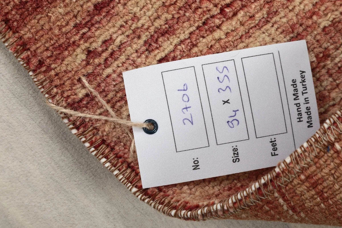Close-up of the rug's pile and a tag displaying the size and origin information.