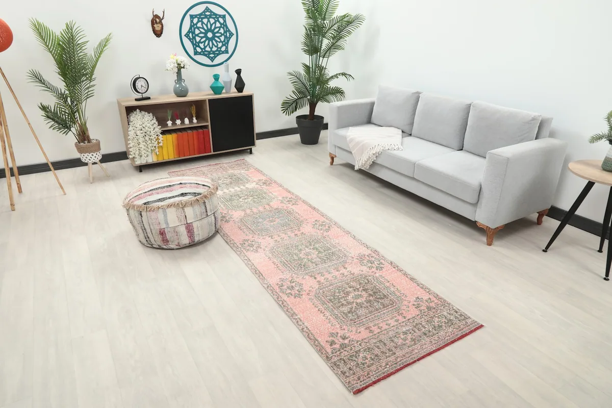 Angle view of the rose and gray runner rug in a contemporary room setting, showing its length.