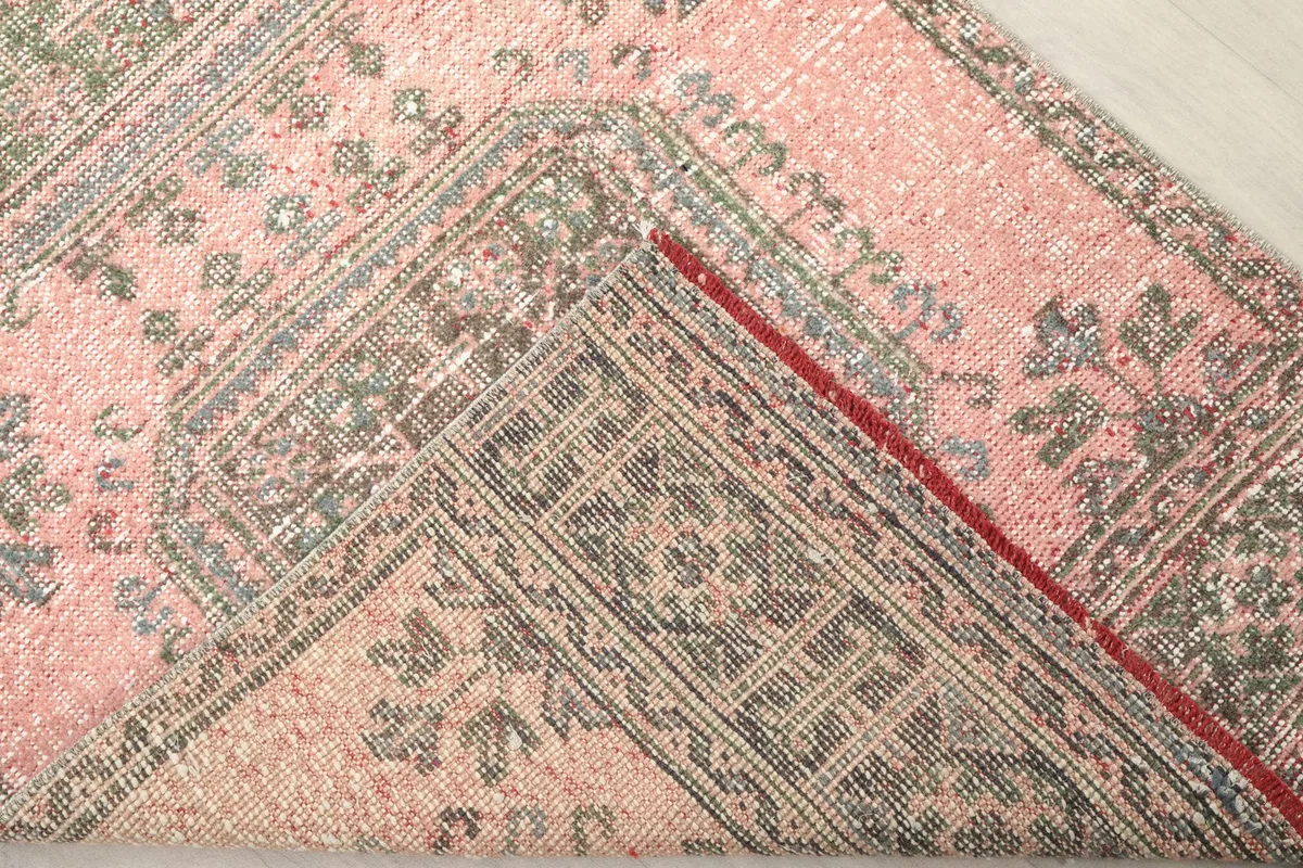 View of the back of the rug, showing the intricate hand-knotting and cotton foundation.