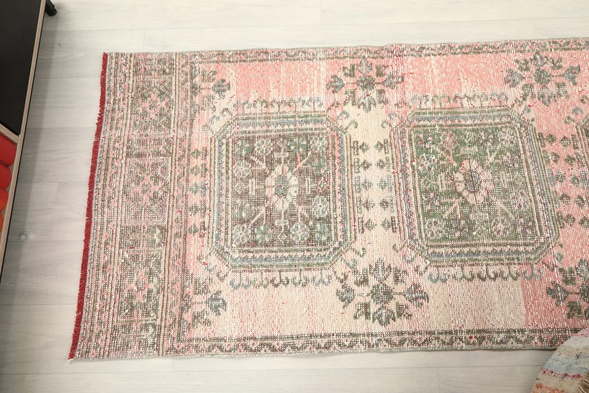 Overhead view showing a section of the runner rug, including two geometric medallion motifs.
