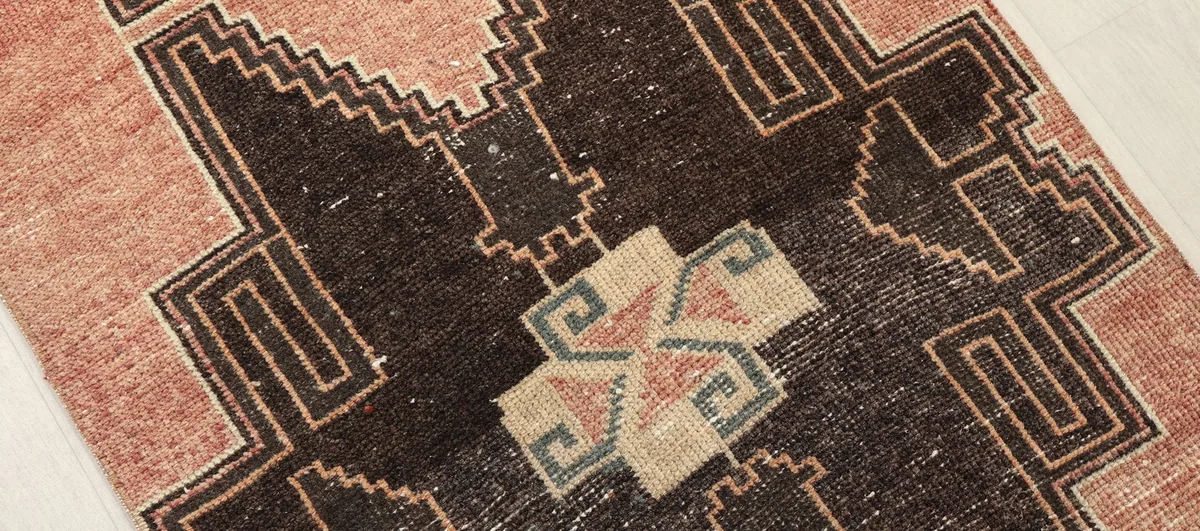 Close-up of a central black and beige geometric motif with olive accents.