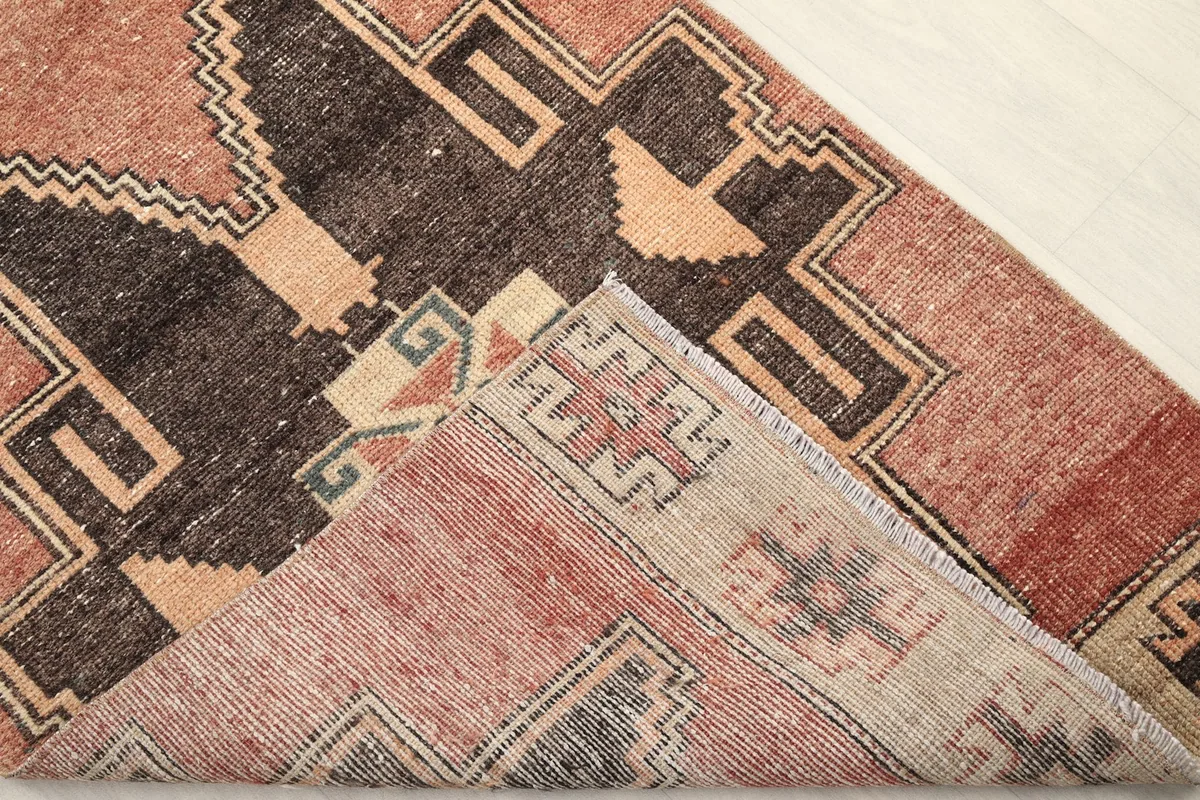 View of the rug's underside, revealing the hand-knotted cotton foundation and wool pile.
