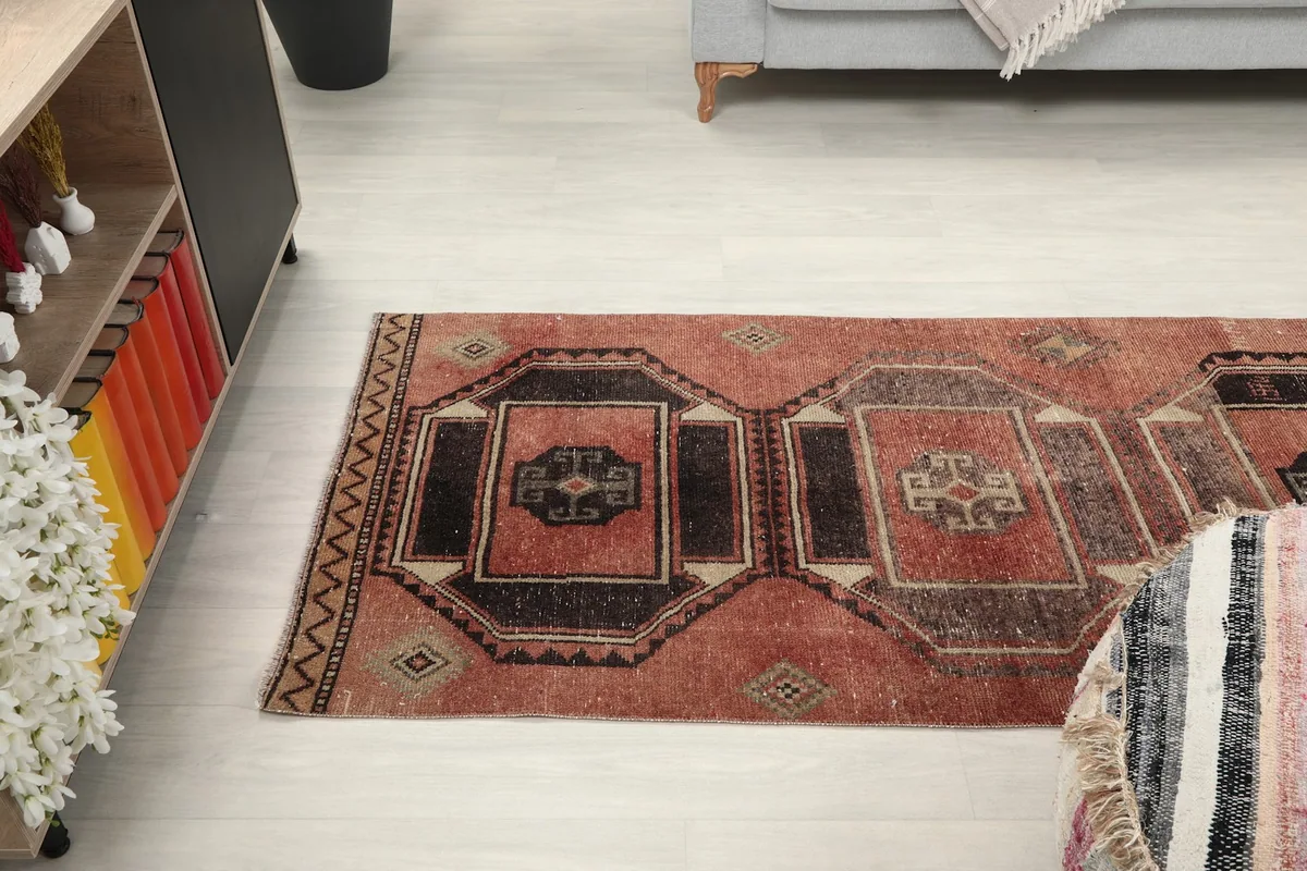 View of the runner rug extending from a living area towards a shelving unit