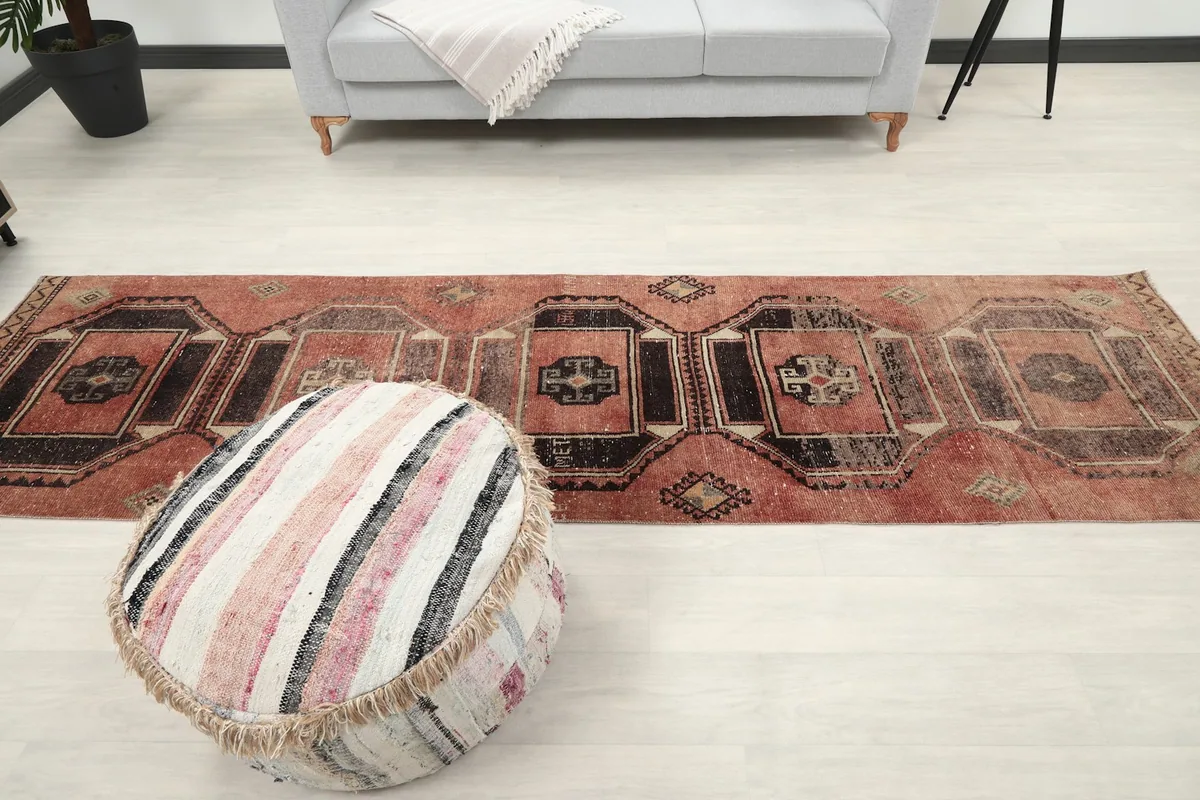 Runner rug in a room setting from a slightly elevated perspective, with a decorative ottoman