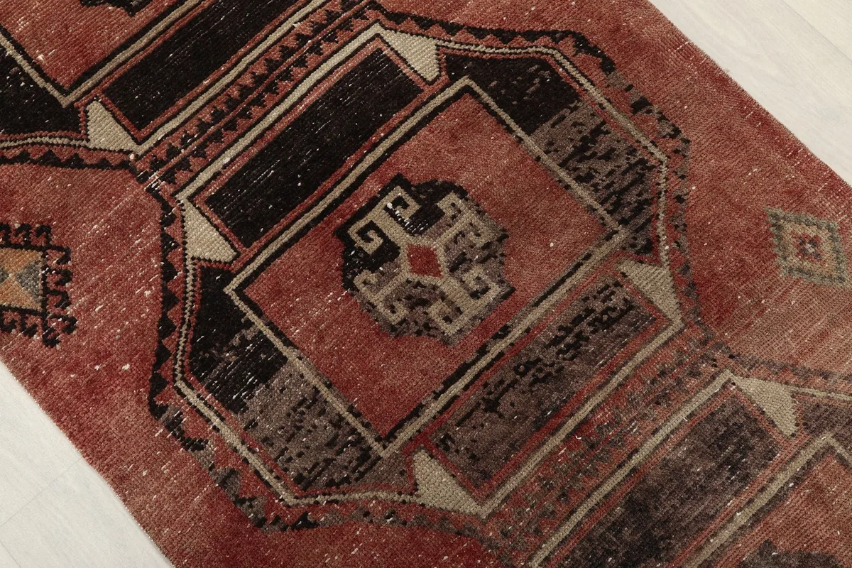 Close-up of a central black and rust geometric medallion with beige accents