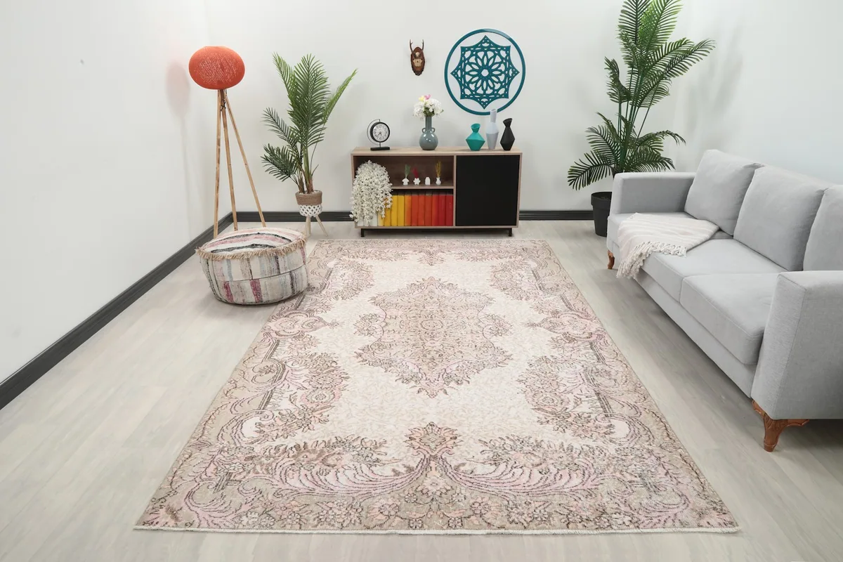 Vintage Anatolian rug in a living room setting, showing its scale and design next to a sofa