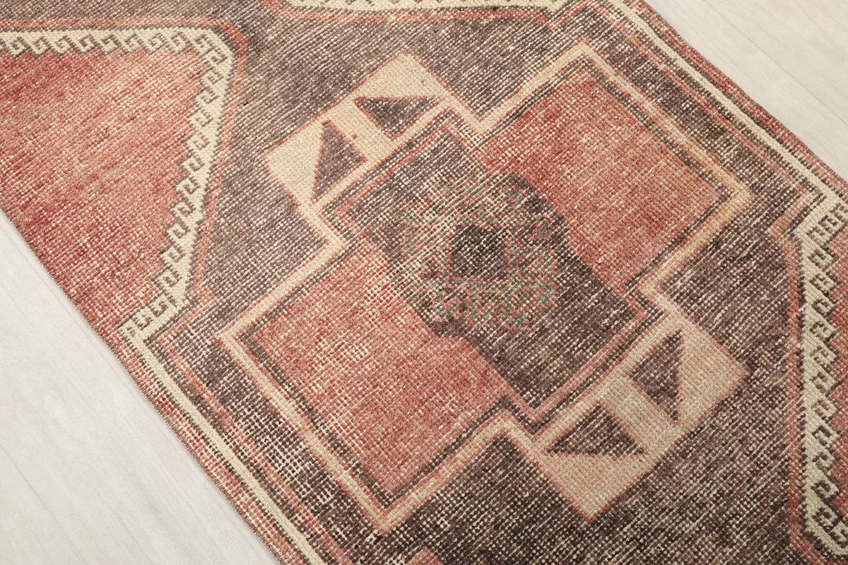 Close-up detail of the central gray and beige geometric motifs within the Rust Gray Geometric Anatolian Runner.