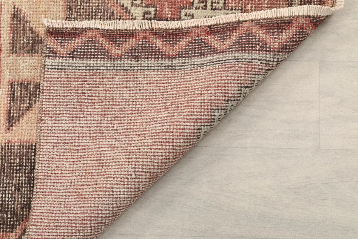 Another view of the back of the Rust Gray Geometric Anatolian Runner, showing the weave and fringe.