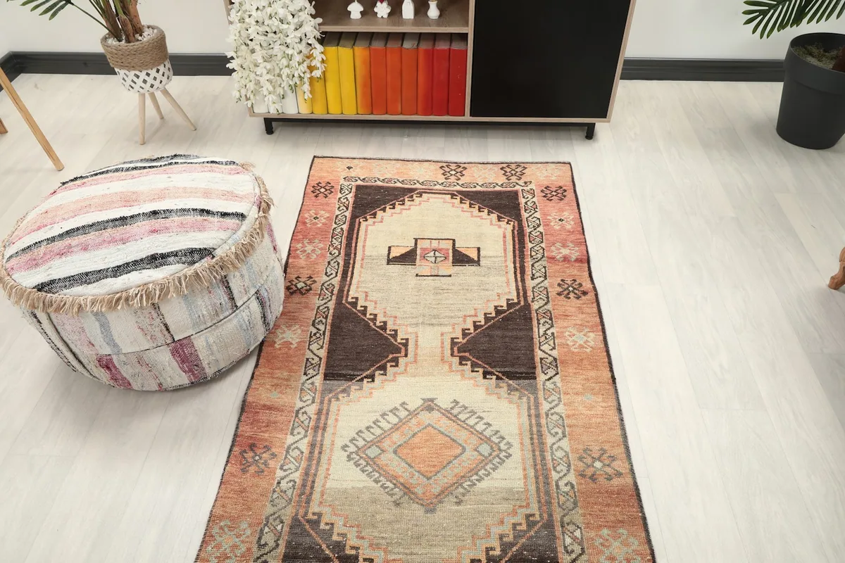 Full view of the rust and tan runner rug in a room, emphasizing its length