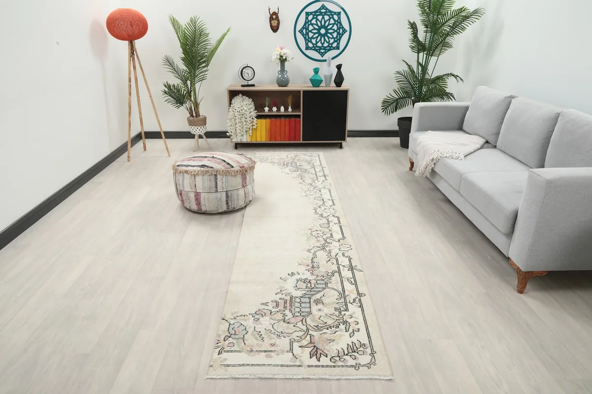 Vintage Anatolian runner rug displayed in a modern hallway with a gray sofa and wooden furniture.