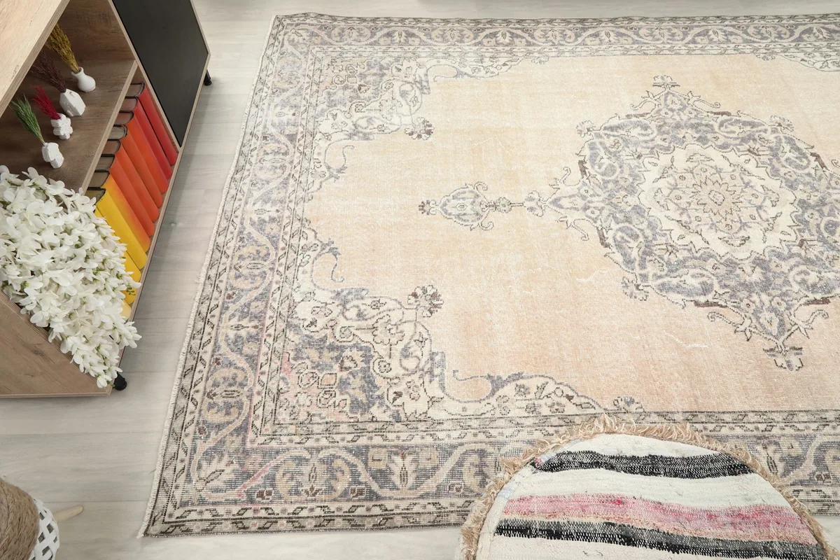Side angle view of the ivory and gray vintage rug, showing its placement in a room
