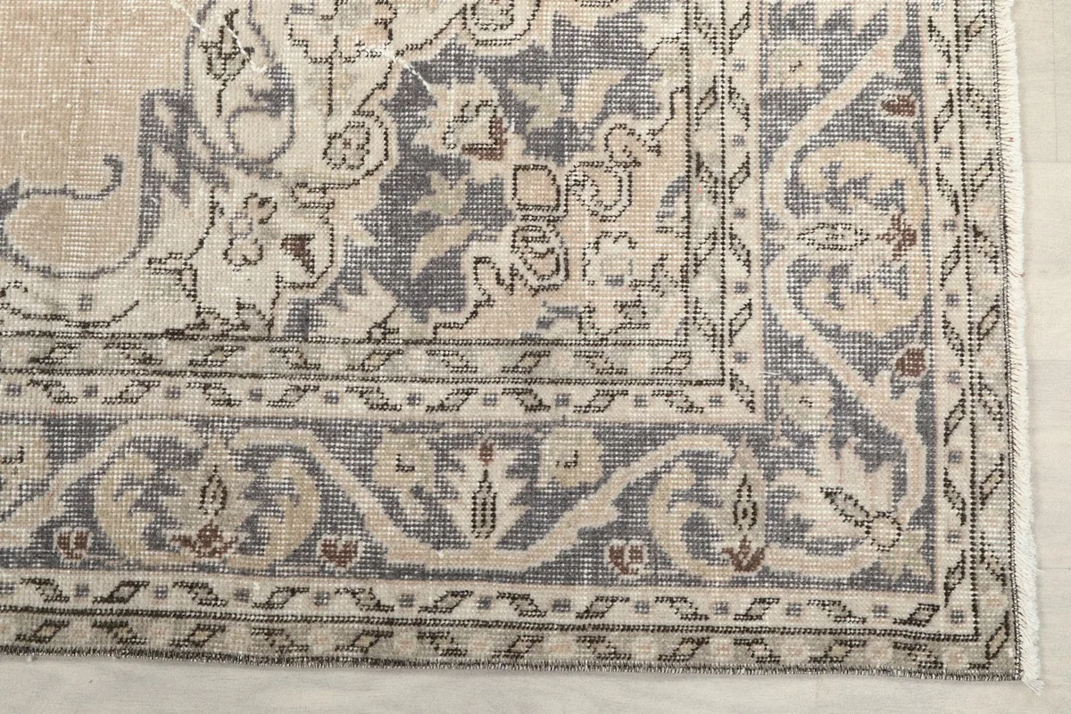 Detailed view of the gray geometric border pattern on the vintage Anatolian rug