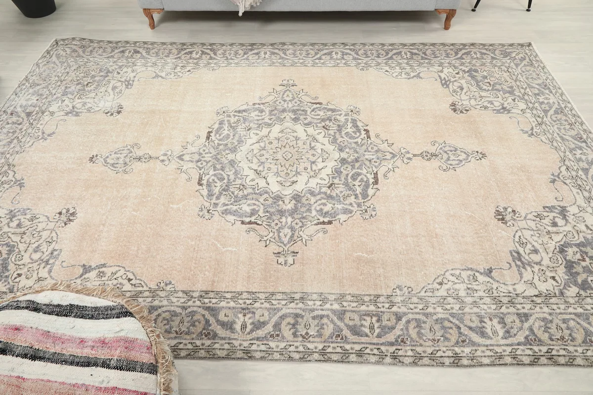 Overhead view of the ivory and gray vintage rug, capturing the full medallion and border design