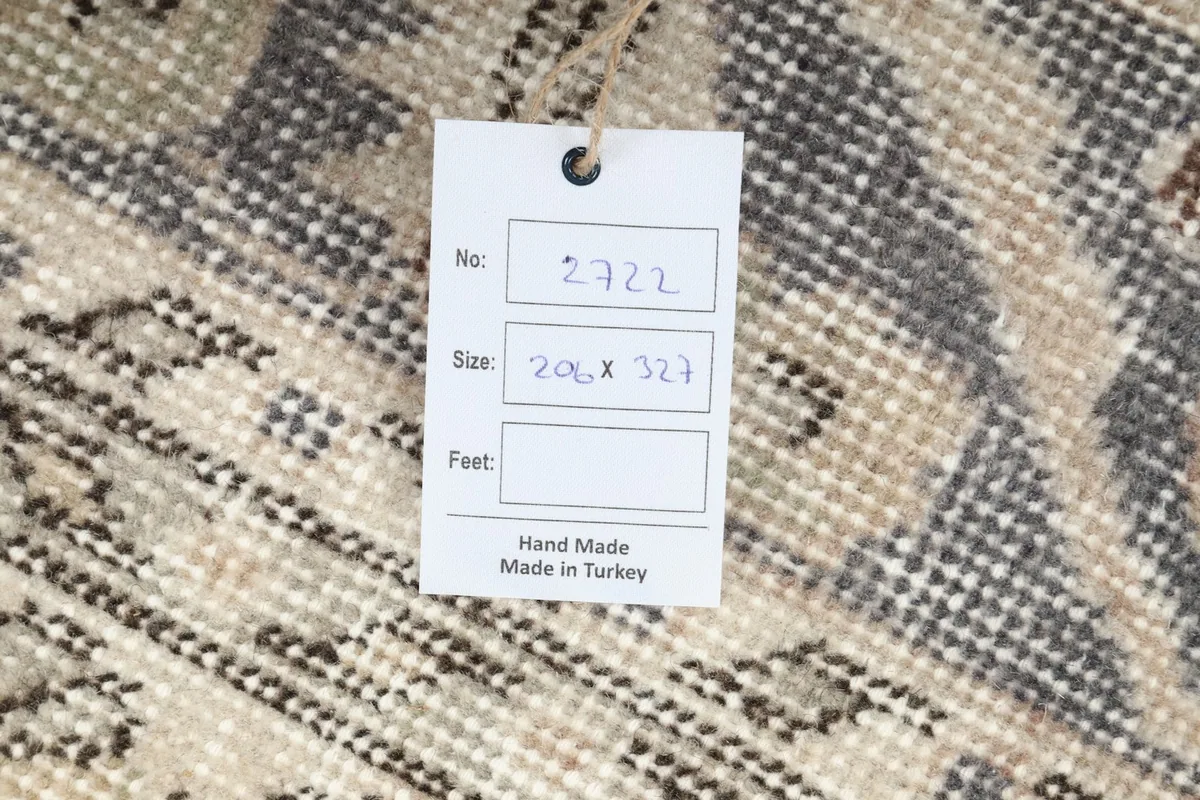 Product tag on the back of the rug indicating handmade origin and size in centimeters