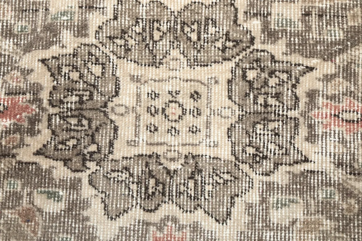 Close-up detail of the central medallion's intricate design and texture of the wool pile.