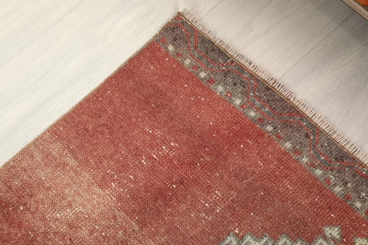 Corner detail of the runner rug, showing the border pattern and fringe