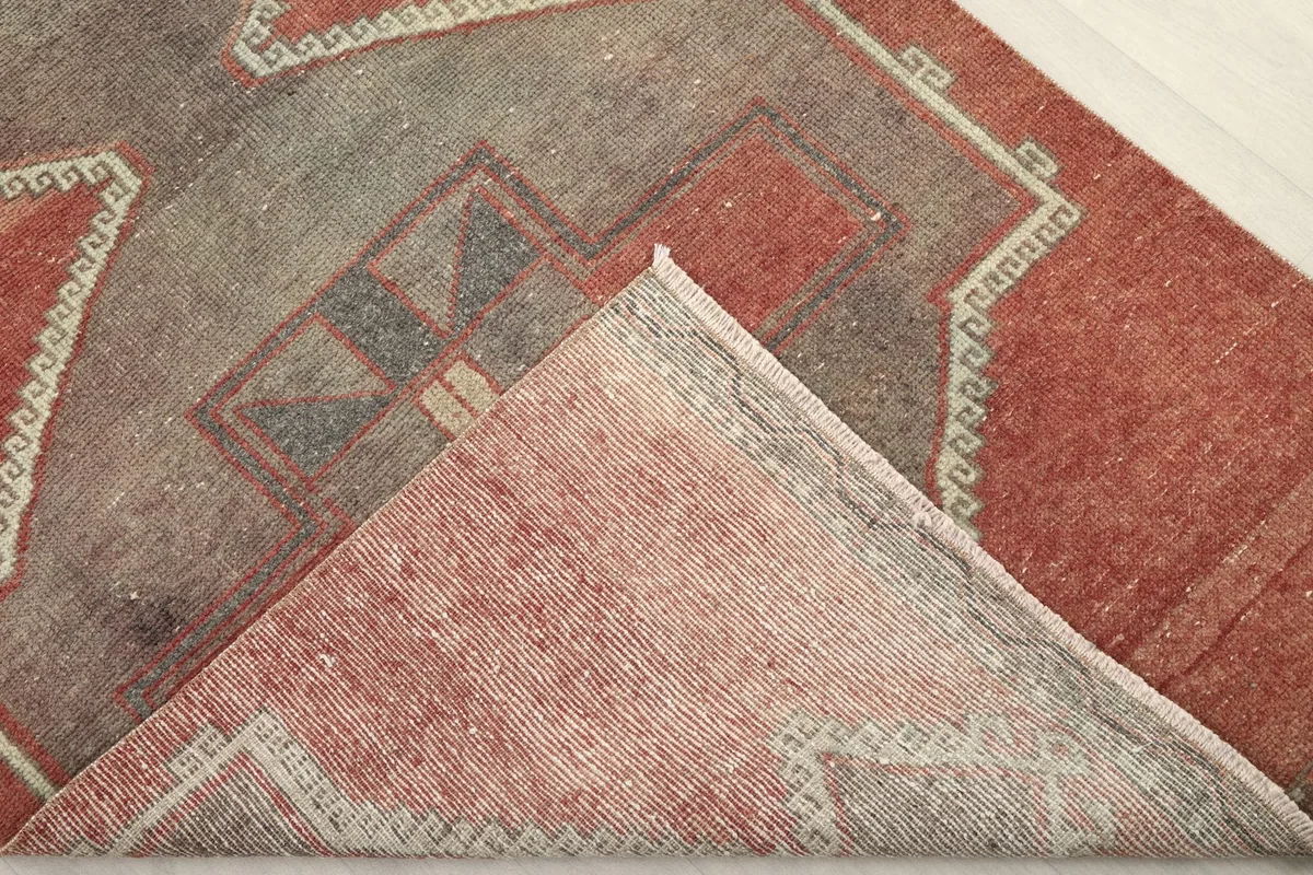 View of the back of the hand-knotted wool pile rug, showing the cotton foundation