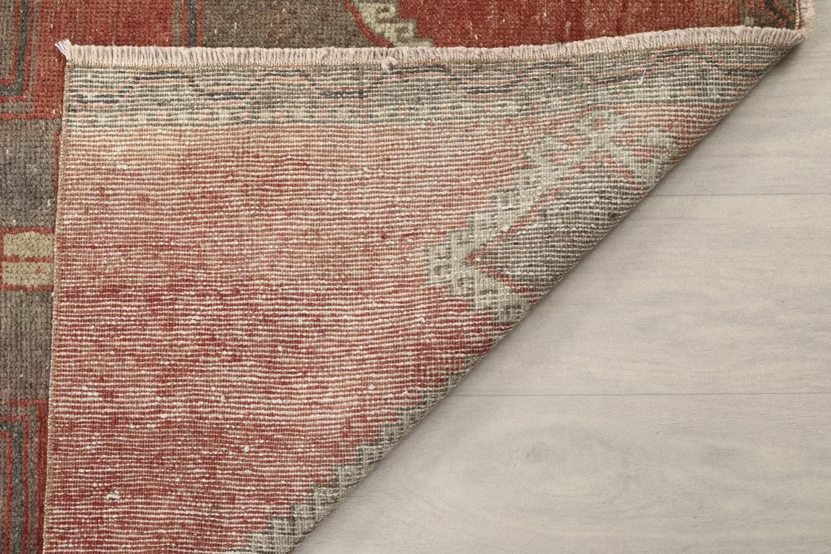 Folded corner of the rug revealing the tightly woven cotton foundation and wool pile