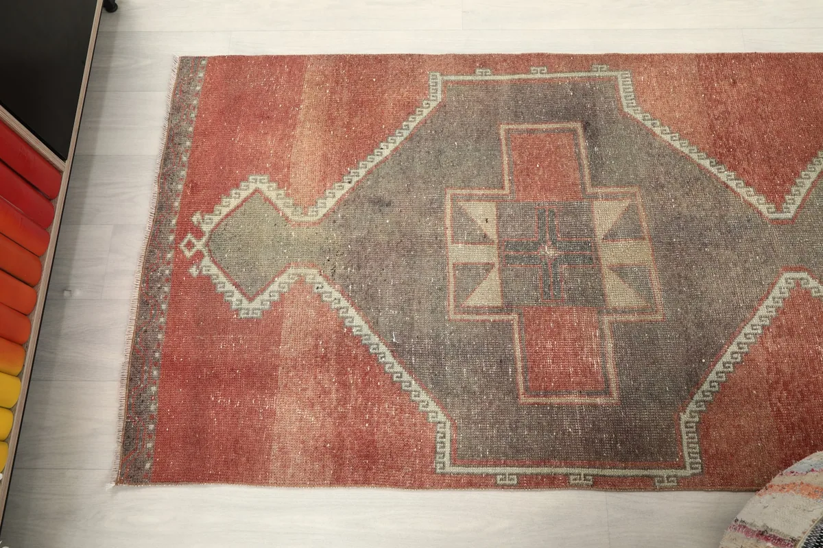 Overhead view showcasing the rust and gray geometric patterns along the length of the rug