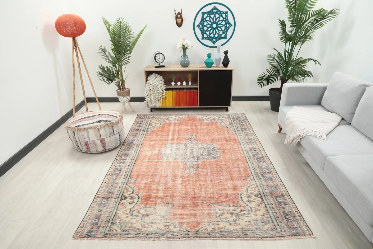 Vintage rust rug displayed in a modern living room setting with a light sofa