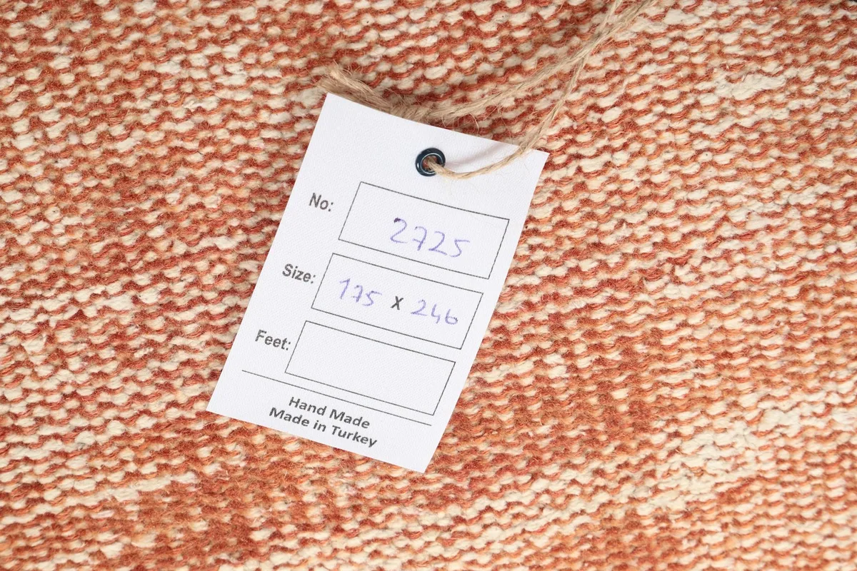 Product tag on the rug, indicating 'Hand Made in Turkey' and rug dimensions