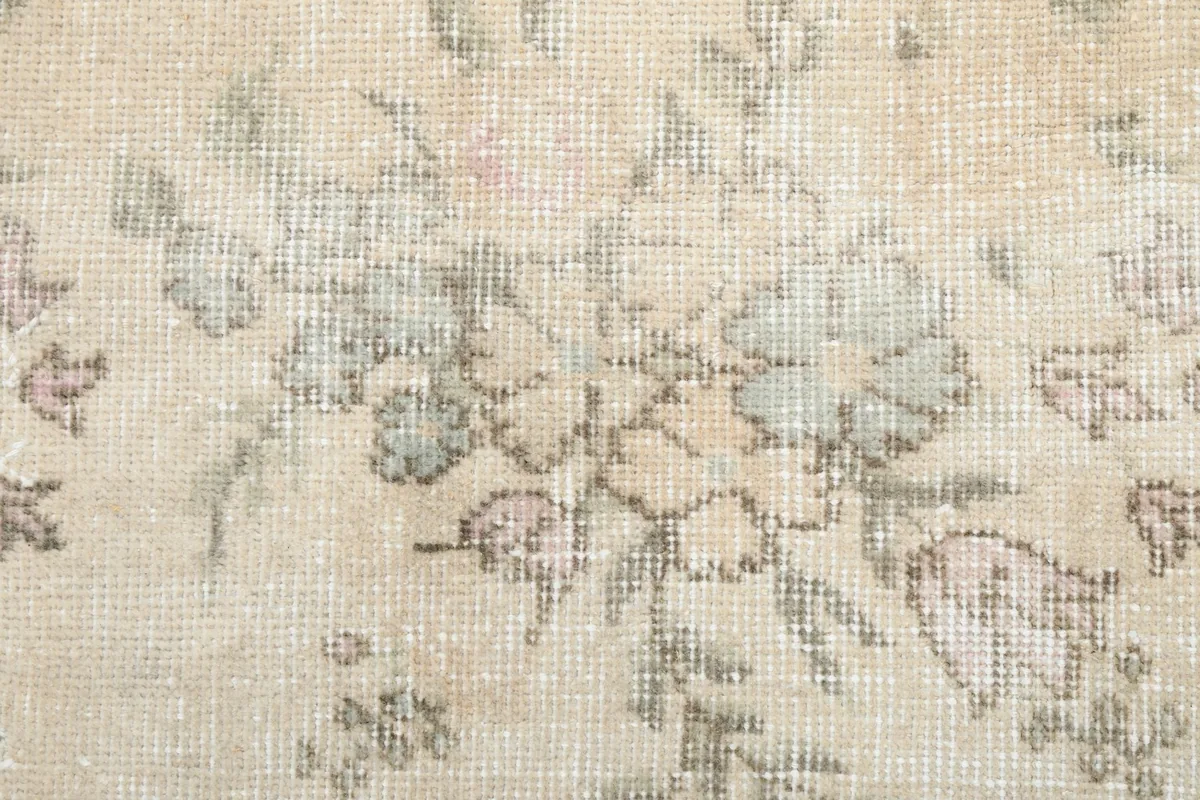 Close-up of a floral motif, highlighting the hand-knotted texture and color variations