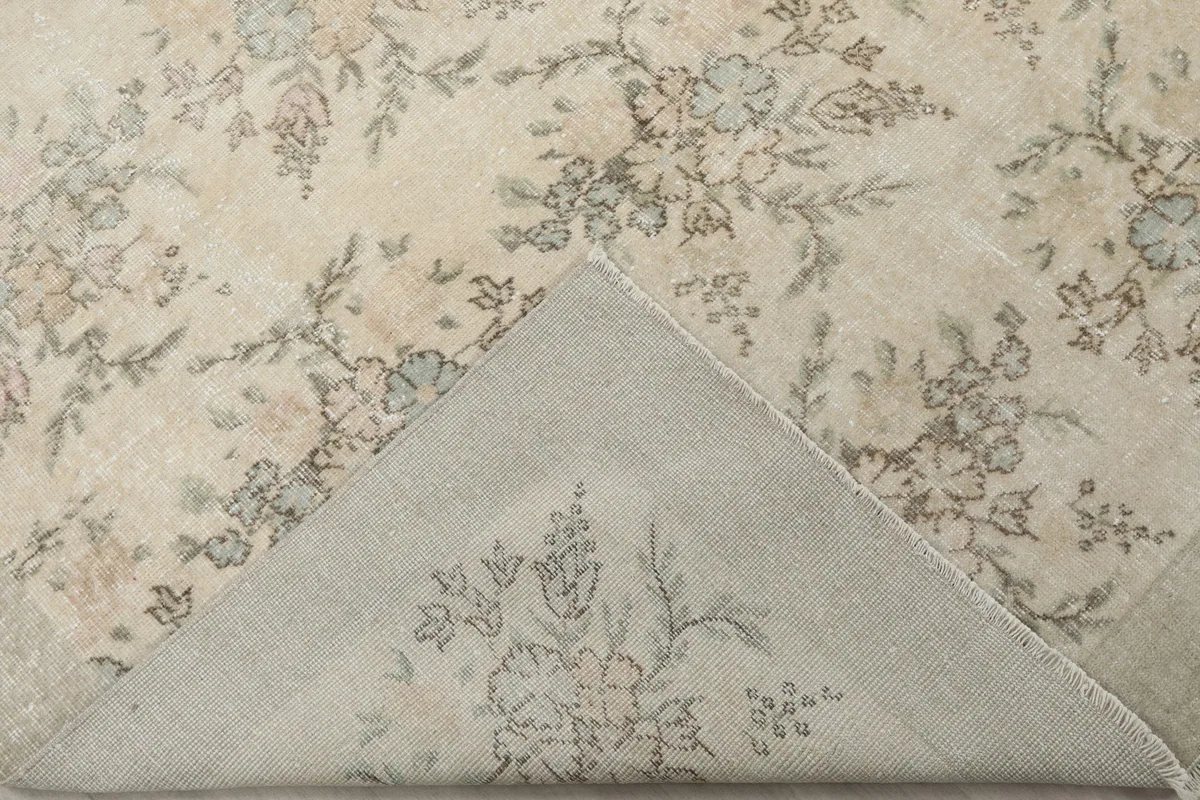 View of the back of the rug, revealing the intricate hand-knotted cotton foundation