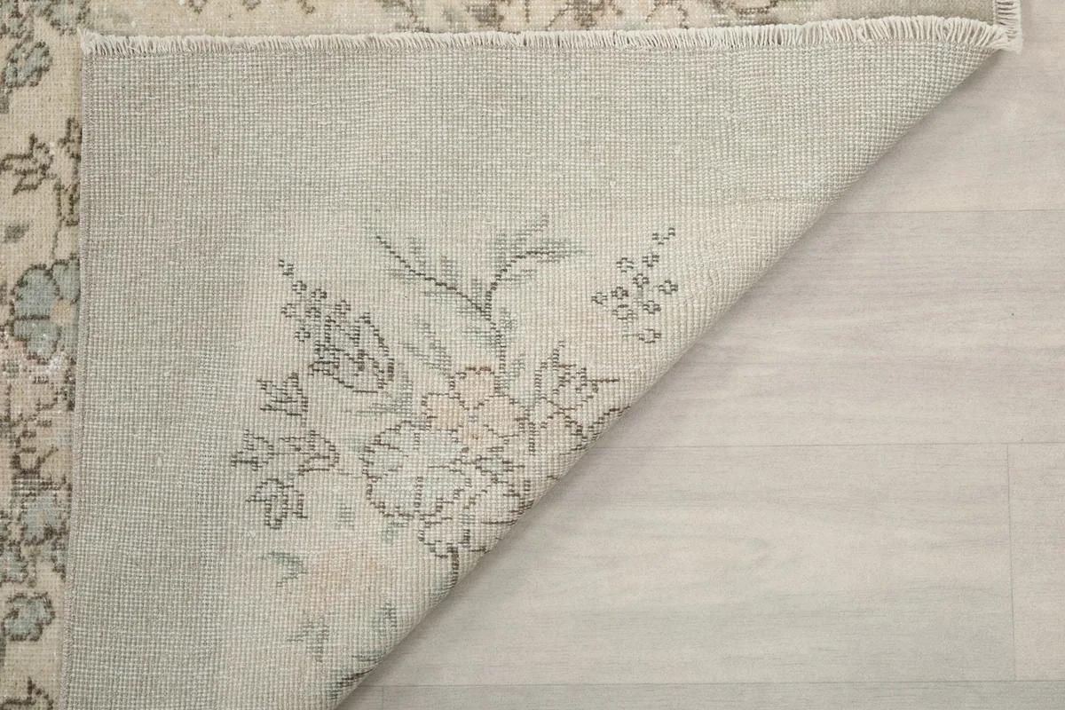 Another view of the rug's back, showing the construction and a folded corner