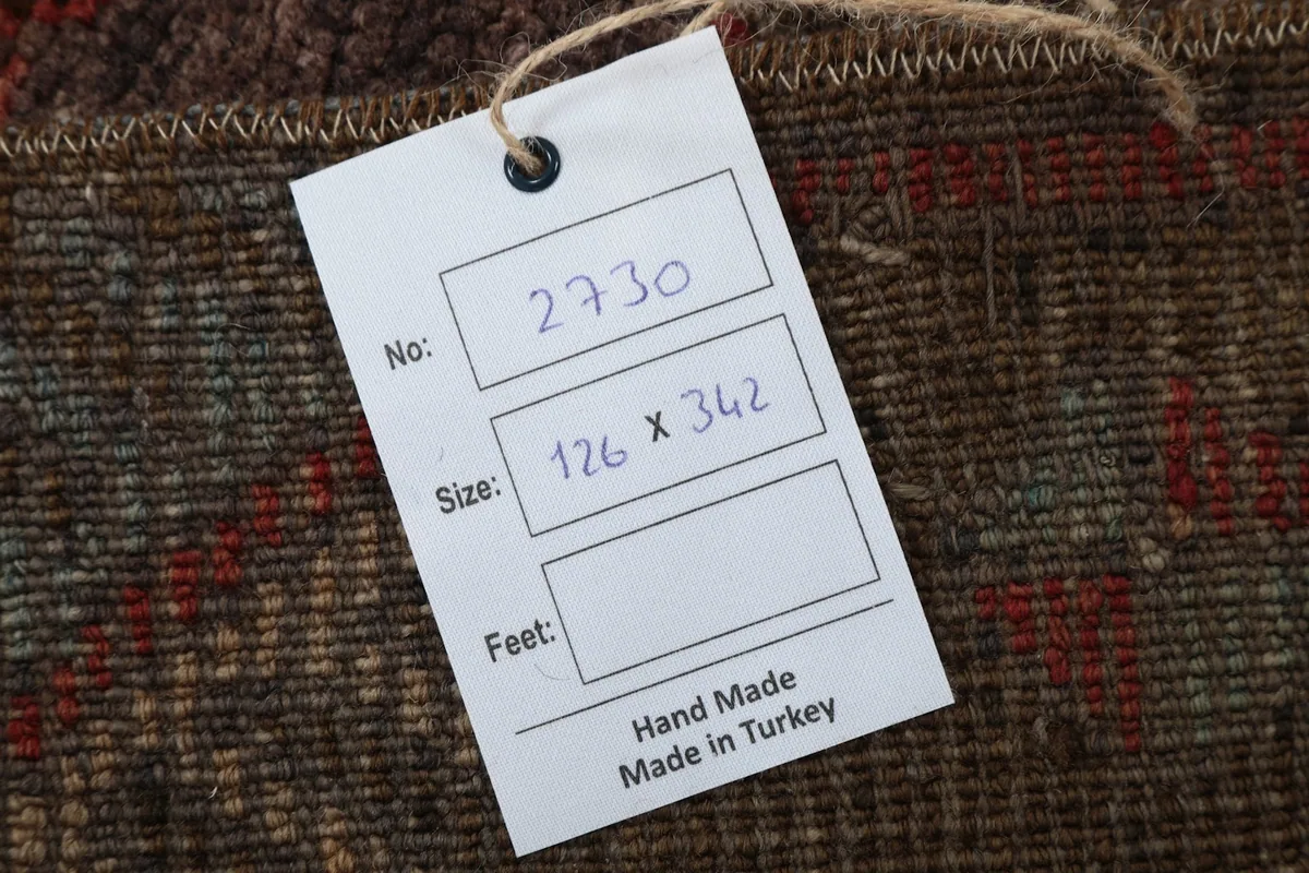 Close-up of the product tag attached to the rug, showing size in centimeters and origin