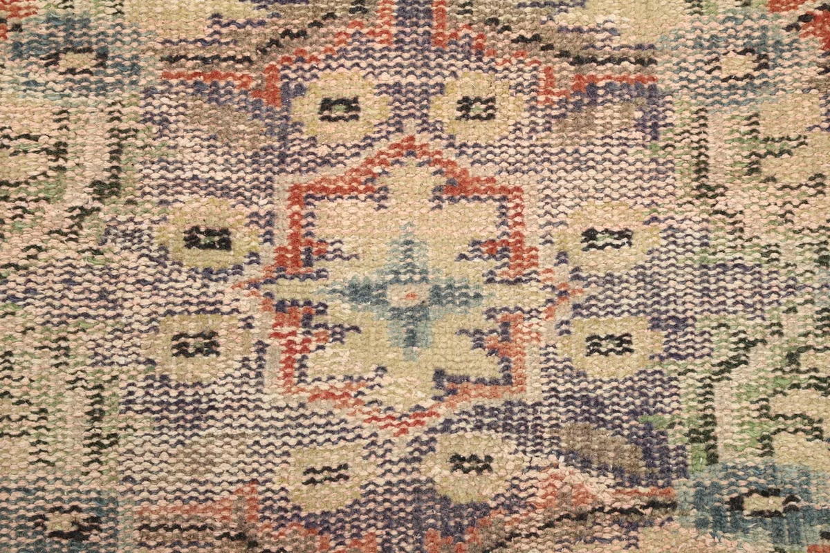 Extreme close-up showing the low pile texture and intricate knotting of the rug's pattern