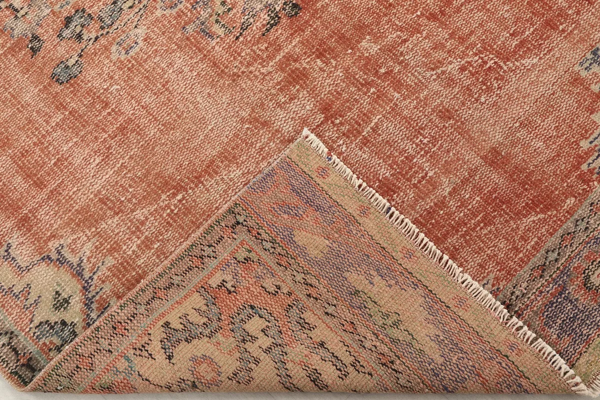 Corner of the rug folded back to show the cotton foundation and reverse side of the knots
