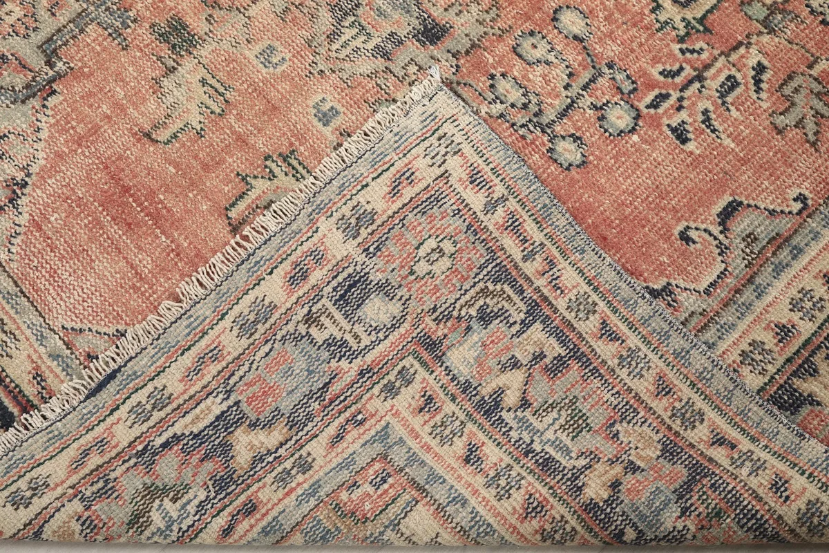 Folded corner of the rug, revealing the reverse side of the hand-knotted construction and fringe