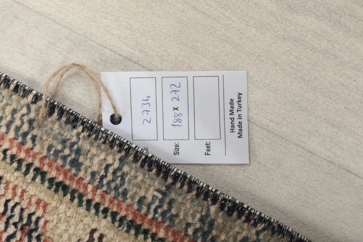 Close-up of the product tag indicating hand-made in Turkey and the rug's dimensions