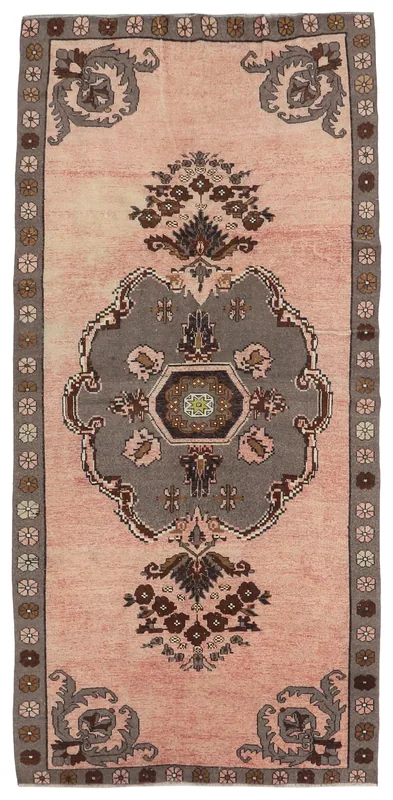 Full overhead view of the vintage rose Anatolian rug with a gray medallion on a white background