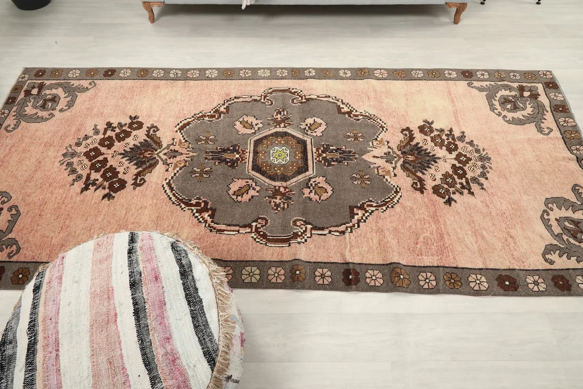 Overhead shot of the rose Anatolian rug, highlighting the central medallion and symmetrical motifs