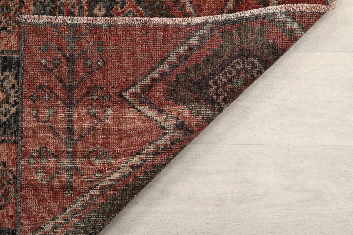 Close-up of the back of the rug, revealing the tight knotting and wool pile on cotton foundation
