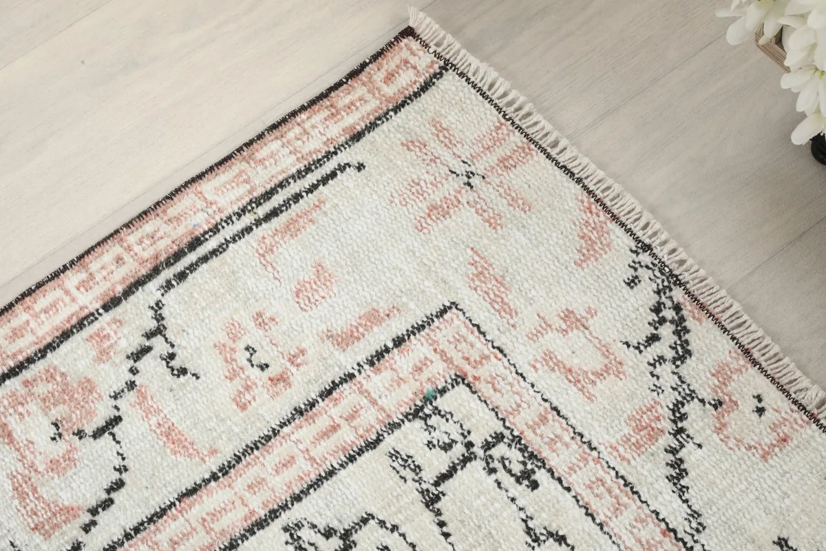 Close-up of the rug's border design and corner with subtle fringe.