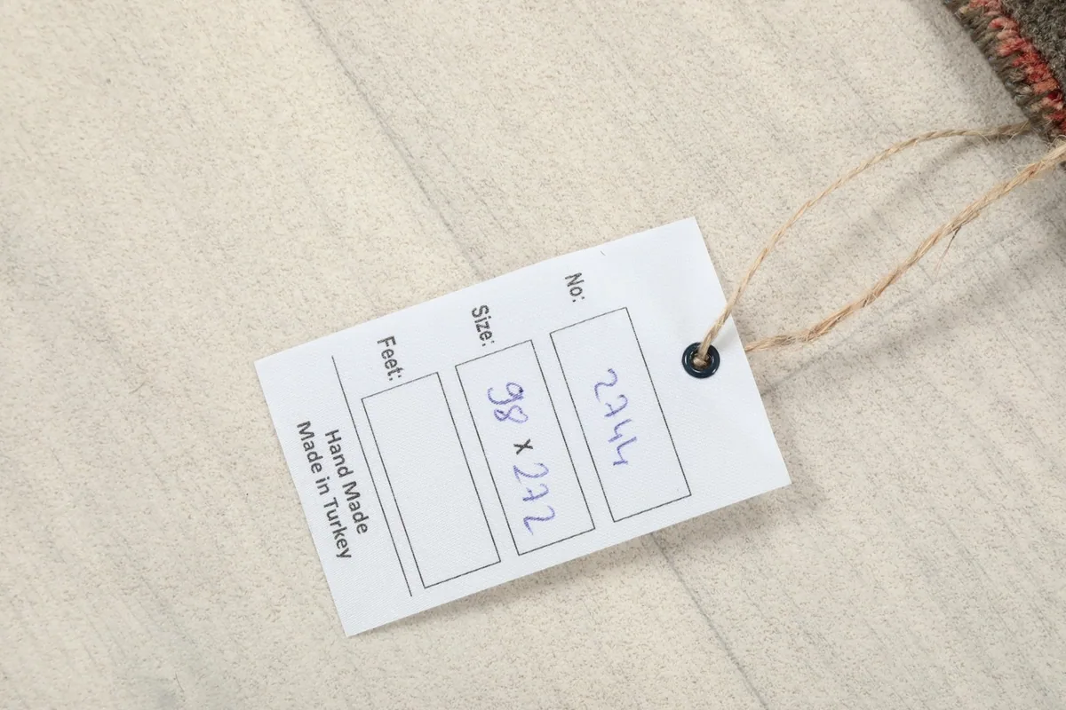 Product tag displaying the rug's dimensions in cm and indicating 'Hand Made in Turkey'