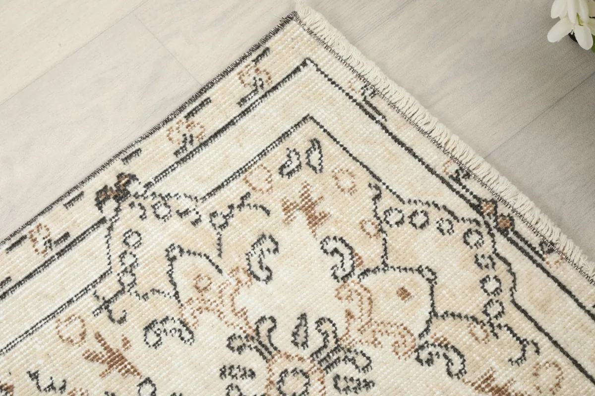 Detailed shot of a rug corner, emphasizing the hand-knotted texture and low pile